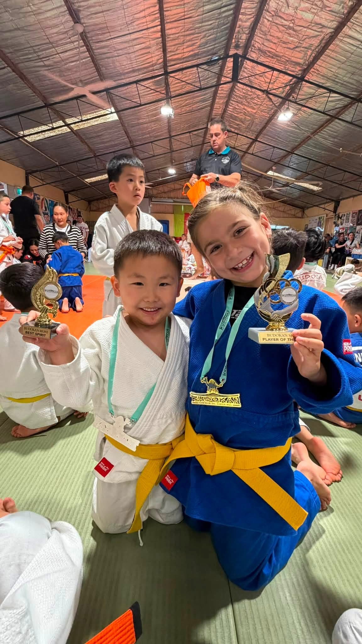 Young judo athletes proudly displaying their awards