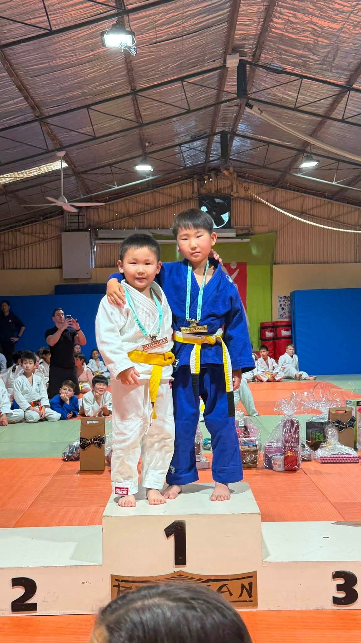 Young judo medalists standing together on the podium